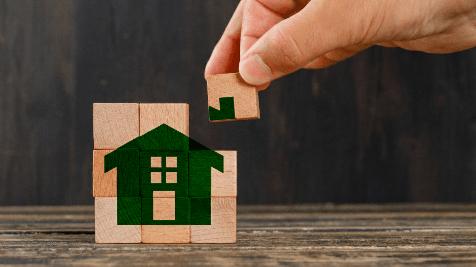 Main assemblant maison verte pour l’assurance habitat à Caen